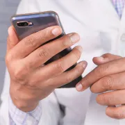 Manos de médico sosteniendo un teléfono móvil, representando contacto y agendamiento de citas en línea en León Gto.