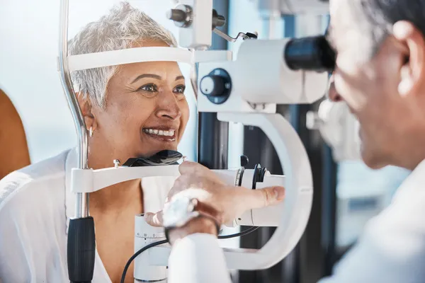 Paciente sonriente durante su revisión periódica con el optometrista para validar su cirugía de glaucoma básica