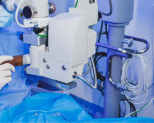 An advanced surgical microscope with multiple lenses and control knobs, a key piece of technology for performing precise eye surgery in Mexico.