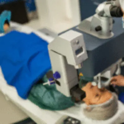 A wide shot of a modern operating room with a prominent laser system, demonstrating the complete setup for an advanced eye surgery in Mexico.