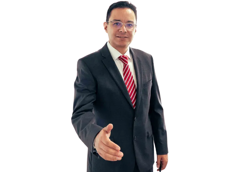 A male ophtlamologist in Mexico wearing a black suit, glasses, and a red striped tie extends his hand for a handshake.